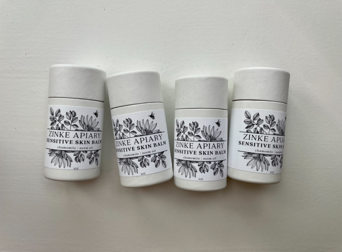 Four containers of Zinke Apiary Sensitive Skin Balm on a light gray background