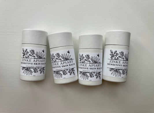 Four containers of Zinke Apiary Sensitive Skin Balm on a light gray background