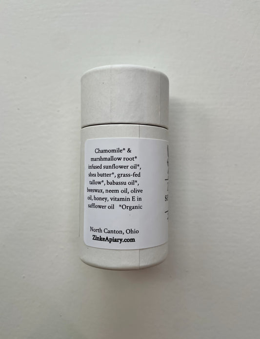 White cylindrical container with a label on a light gray background