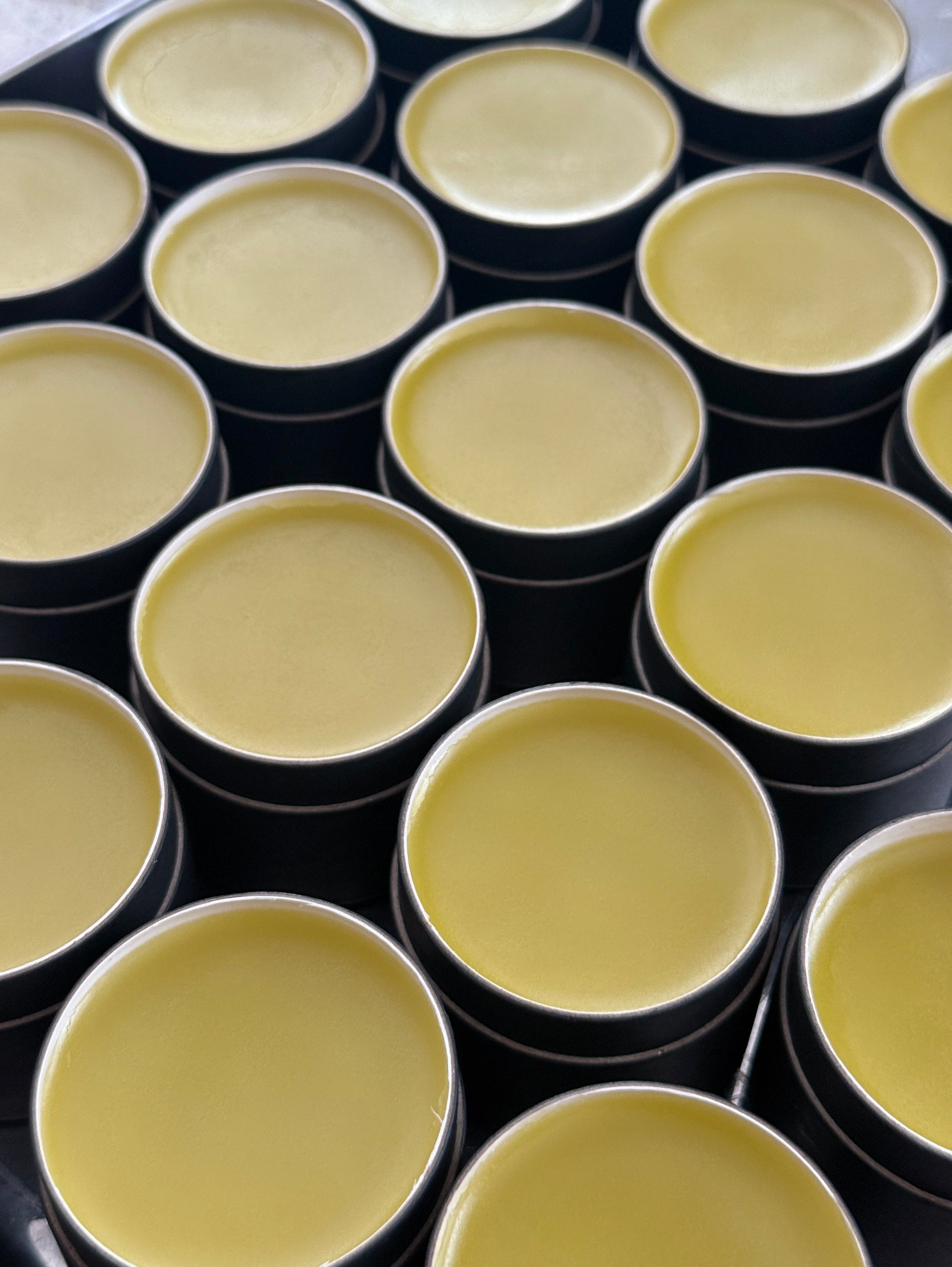 Multiple black containers with yellowish contents arranged in a grid pattern.