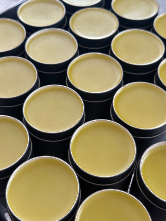 Multiple black containers with yellowish contents arranged in a grid pattern.