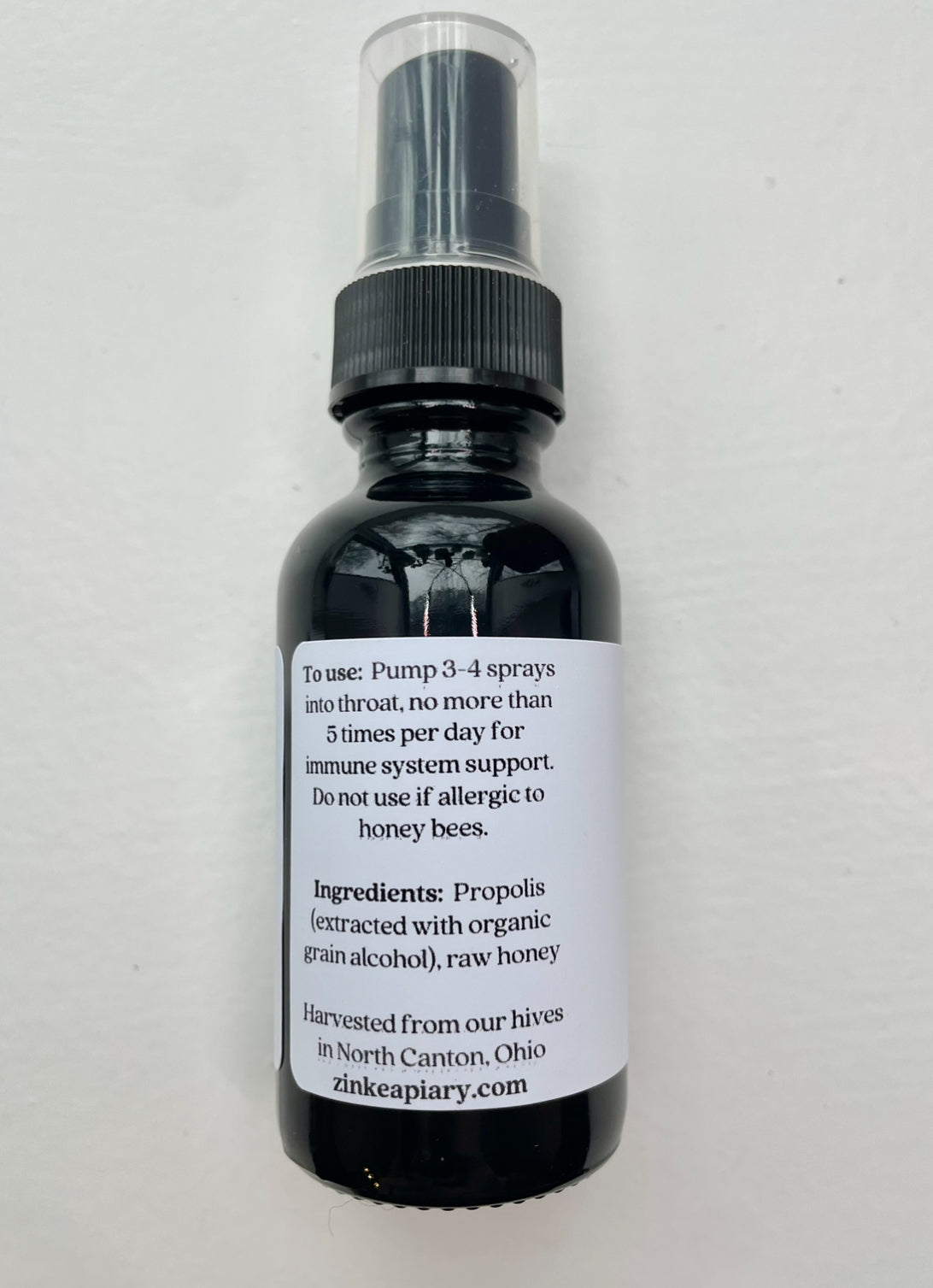 Bottle of propolis spray with label on a white background